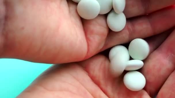 Una donna si versa pillole in mano per bere e avvelenarsi. Concetto di overdose, medicina e assistenza sanitaria. Una dose per la morte. Eccesso di farmaci nel trattamento moderno. Capsule su fondo blu — Video Stock