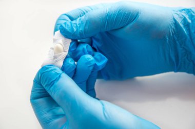 Eldivenli bir doktor anal ya da vajinal kullanım için fitil açar. Candida tedavisi için tıbbi mumlar, ardıç kuşu, hemoroit, iltihap ve ateş. Beyaz arka planda etkili uyuşturucu