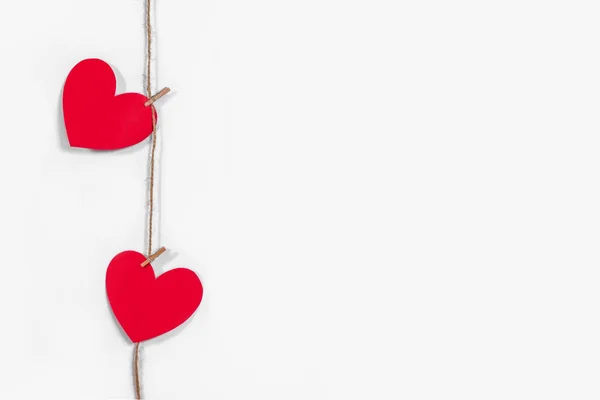 Guirlande de cœurs rouges sur fond blanc isolé. Corde et pinces à linge naturelles. Le concept de reconnaissance dans l'amour, les relations amoureuses, la Saint-Valentin. Espace de copie — Photo