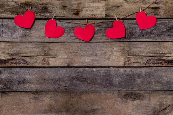 Vieux fond en bois avec une guirlande de cœurs rouges. Corde et pinces à linge naturelles. Concept de reconnaissance de l'amour, relations amoureuses, Saint Valentin en style grunge. Espace de copie — Photo