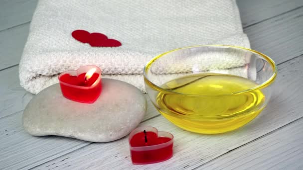 The concept of a Spa on Valentines Day. A beautician girl blows out candles in shape of a red heart. End of relaxation and Wellness sessions in cosmetologists office. Bath procedure, cosmetology — Stockvideo