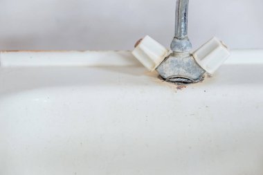 Eski paslı kirli musluk lavaboda. Sıcak ve soğuk su eksikliği, tesisat tamiri. Ödenmemiş faturalar için suyu kapatma kavramı. Boşluğu kopyala