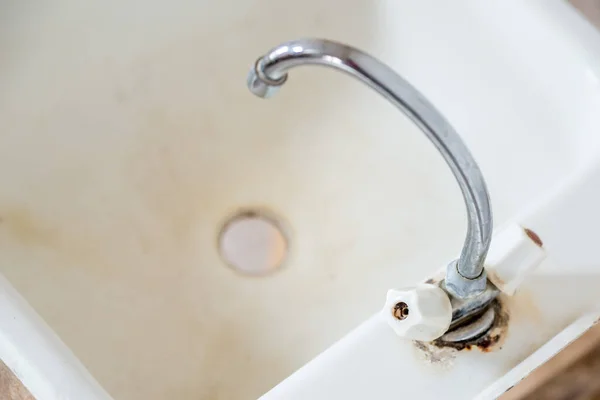 Vecchio rubinetto sporco arrugginito sul lavabo. Non c'è acqua calda o fredda nel rubinetto e l'approvvigionamento idrico è in riparazione. Il concetto di spegnere l'acqua per il mancato pagamento delle utenze. Copia spazio — Foto Stock