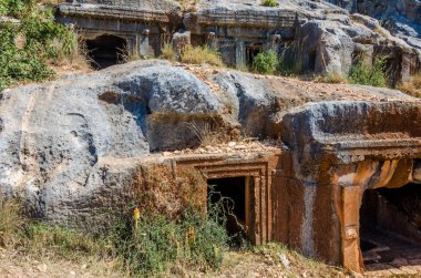 Türkiye 'nin Limyra ilindeki antik mezarlık. Kayadaki eski beton mezarın girişi. Mimarinin tarihi anıtına bir gezi. Ataların gökyüzüne daha yakın gömülmesi..