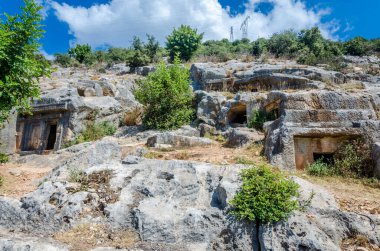Türkiye 'nin Limyra ilindeki antik mezarlık. Kayadaki eski beton mezarın girişi. Mimarinin tarihi anıtına bir gezi. Ataların gökyüzüne daha yakın gömülmesi..