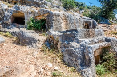 Türkiye 'nin Limyra ilindeki antik mezarlık. Kayadaki eski beton mezarın girişi. Mimarinin tarihi anıtına bir gezi. Ataların gökyüzüne daha yakın gömülmesi..