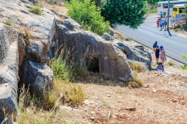 Limyra, Türkiye 'de 11 Haziran 2018' de antik bir antik mezarlık turunda. Kayadaki eski beton mezarın girişi. Mimarinin tarihi anıtı. Ataların gökyüzüne daha yakın gömülmesi..