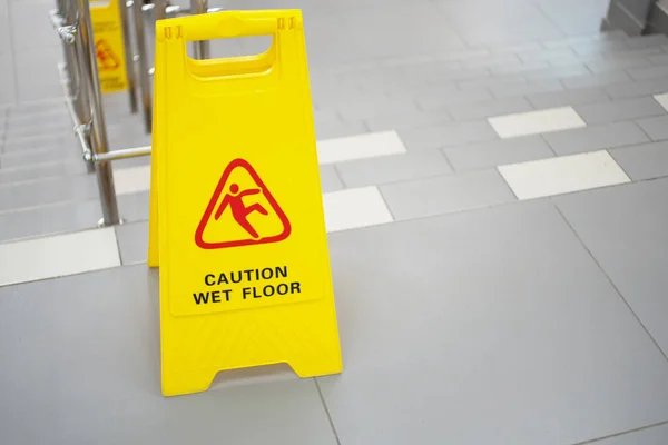 Varningsskylt med texten försiktig våt golv. En skylt nära trappan i ett kontor eller nöjescentrum. Rengöring keramiska plattor i en butik. Kopiera utrymme. — Stockfoto