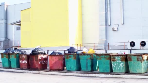 Contenedores de basura desbordantes con basura cerca de un edificio industrial. Problema ambiental de la eliminación de residuos sólidos en una gran ciudad. Concepto de contaminación ambiental . — Vídeos de Stock