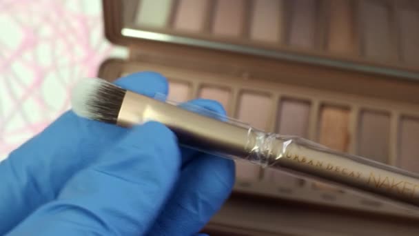 Presentation in the store of the new palette of makeup shadows naked 3 from Urban Decay. Soft elastic double-sided brush close -up. Review of cosmetics for women. Volgodonsk, Russia-March 11, 2020. — Stock Video