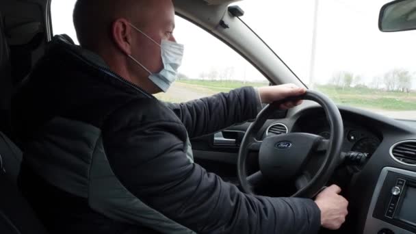 Ein Mann Steuer Eines Autos Mit Einer Schutzmaske Dreht Den — Stockvideo