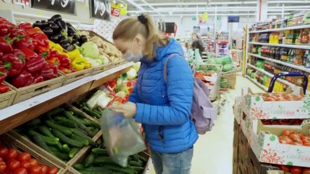 保護医療マスクの少女が食べ物を求めてスーパーで買い物をしている 隔離中の店舗での保護とコロナウイルスのパンデミック ロシア ヴォルゴンドスク2020年4月16日 — ストック動画