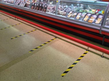 Boş dükkan. Dükkanda sosyal mesafeler. Koronavirüs salgını sırasında güvenli bir mesafede kuyrukta beklemek için zemindeki çizgilerin işaretlenmesi. Rusya, Volgodonsk 3 Nisan 2020