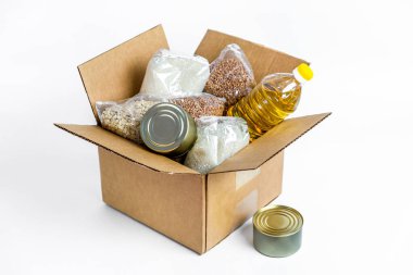 Food in cardboard donation box, isolated on white background. Anti-crisis stock of essential goods for period of quarantine isolation. Food delivery, coronavirus. The shortage of food clipart