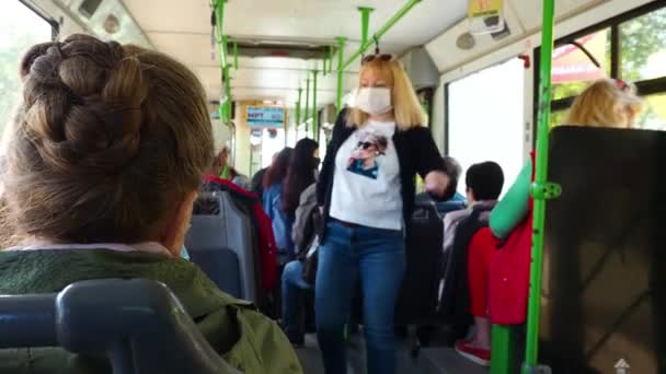 保護マスクの女性が公共交通機関に乗っています。バスの乗客はコロナウイルスから保護されています。流行期の生活様式です。ロシアのヴォルゴンドスク2020年5月. — ストック動画