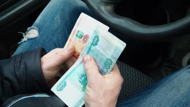 Een man telt geld. Veel roebel bankbiljetten in de handen van een man. Salaris van een Russische taxichauffeur. Een nieuwe auto kopen. Omkoping van een verkeerspolitie-inspecteur wegens overtreding van de verkeersregels. — Stockvideo