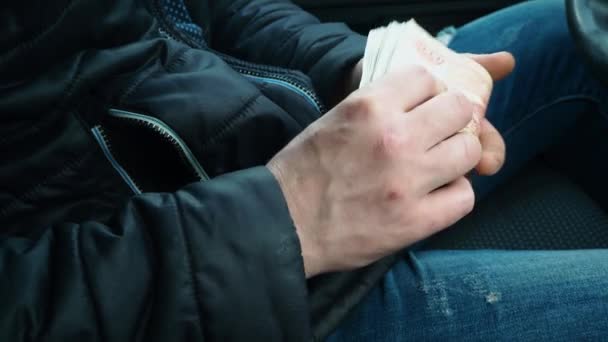 L'homme met de l'argent dans sa poche. Beaucoup de billets de banque en rouble entre les mains d'un homme. Salaire du chauffeur de taxi russe. Achat de voiture neuve. Corruption et activités illégales. Une transaction commerciale rentable . — Video