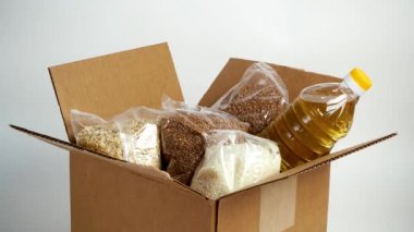Karton bağış kutusunda yiyecek, beyaz arka planda izole edilmiş. Karantina süresi için gerekli malların kriz önleyici stoku. Yemek teslimatı, koronavirüs. Yiyecek kıtlığı..
