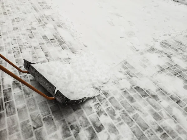Kar Küreği Karla Kaplı Fayanslardan Oluşan Bir Arka Planda — Stok fotoğraf