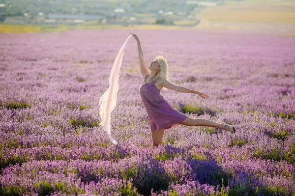 Menina bonita em um campo de lavanda no pôr do sol . — Fotografia de Stock