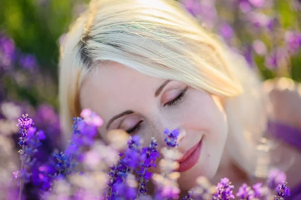 Menina bonita em um campo de lavanda no pôr do sol . — Fotografia de Stock