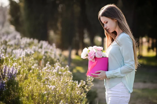 Menina bonita com flores em mãos ao ar livre — Fotografia de Stock