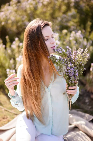 Menina bonita com flores em mãos ao ar livre — Fotografia de Stock