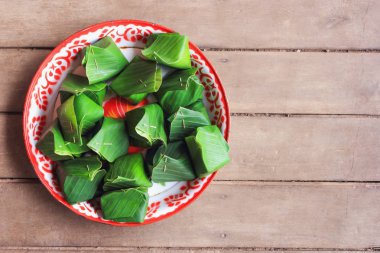 Tay tatlı yapışkan pirinç banan içinde sarılı muhallebi, buğulama.