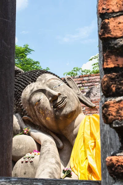 Una gran estatua de buda reclinada con una túnica amarilla — Foto de Stock