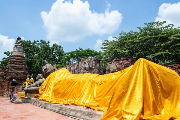 A large statue of reclining buddha with a yellow robe in Ayutthaya — Stock Photo, Image