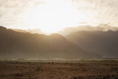 Hindistan 'ın Nubra Vadisi' nde, Leh Ladakh 'ta gündoğumu arka planında çarpıcı bir ışık ve güzel bir sis var. Lens alevli ışık manzarası.