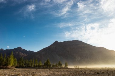 Hindistan 'ın Nubra Vadisi' nde, Leh Ladakh 'ta gündoğumu arka planında çarpıcı bir ışık ve güzel bir sis var. Lens alevli ışık manzarası.