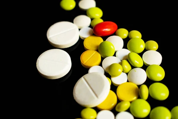 Žluté Bílé Zelené Pilulky Jedna Červená Tobolka Černém Pozadí — Stock fotografie