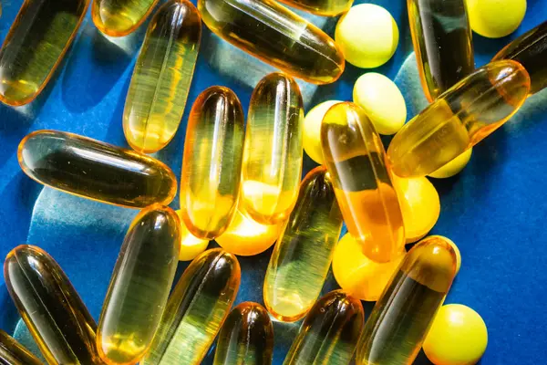 Mavi arka planda renk hapları ve şeffaf kapsül