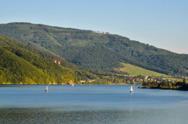 Yaz dağı manzarası. Mavi gölün üzerindeki güzel yeşil tepeler.