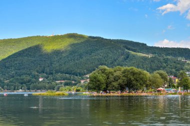 Miedzybrodzie Zywieckie, Polonya - 5 Ağustos 2017: Zar Dağı 'nın altındaki Miedzybrodzkie Gölü kıyısında turistler.