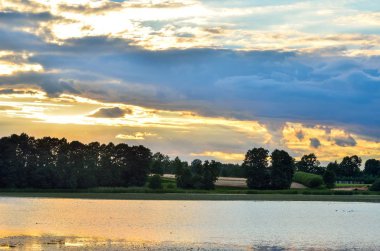 Yaz akşamı manzarası. Suyun üzerinde gün batımı.