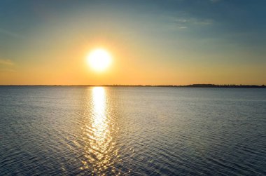 Güneşli yaz manzarası. Gölde güzel bir gün batımı.