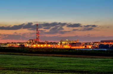 Gece endüstriyel manzarası. Şehirde parlayan fabrikalar.