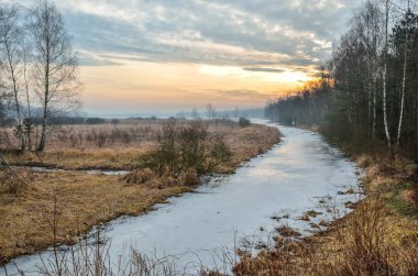 Colorful winter morning. A frozen river with a beautiful sunrise.