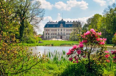 Beautiful historic castle in colorful spring scenery. Neo baroque castle in a park in Pszczyna in Poland. clipart