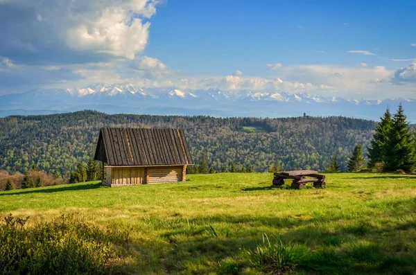 Piękny Wiosenny Krajobraz Drewniana Chata Polanie Ołowiem Ośnieżonych Wysokich Gór — Zdjęcie stockowe