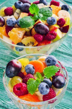 Taze renkli meyve. Ahşap mutfak masasında çeşitli meyve salatası..