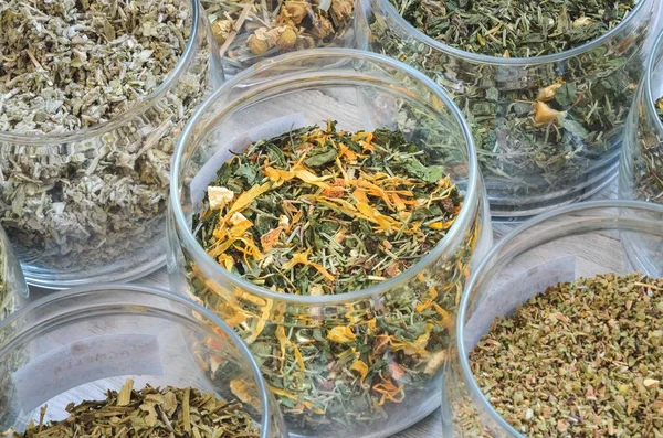 Çeşitli otlar. Kavanozlardaki bitkisel çaylar ahşap bir masada..