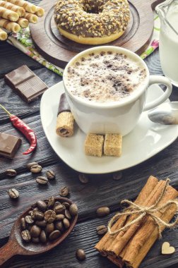 Kahveyi klasik tarzda servis etmenin zarif bir konsepti. Köpüklü kahve ve çeşitli tatlılar ve dekorasyonlu tarçın..