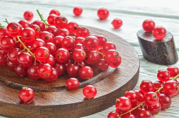 Red fruit in the kitchen. Red currant on a white wooden table.