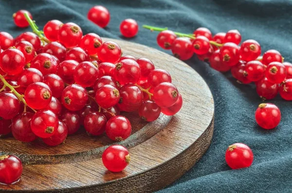 Red fruit in the kitchen. Red currant on a dark fabric background.