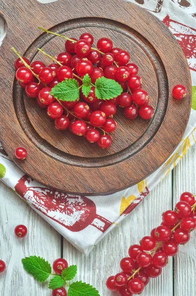 Red fruit in the kitchen. Red currant on a white wooden table.