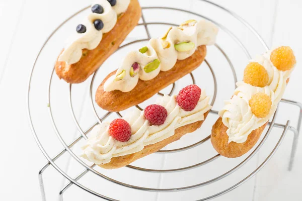 Eclairs à la crème vanille sur fond blanc — Photo