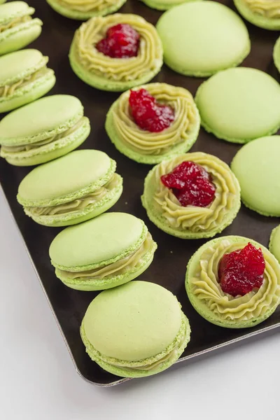 Green macaroons with pistachios ganache cream and raspberries co — Stock Photo, Image
